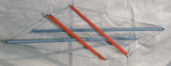 view of skew red-blue dowel-and-fishing-line tensegrity four-prism