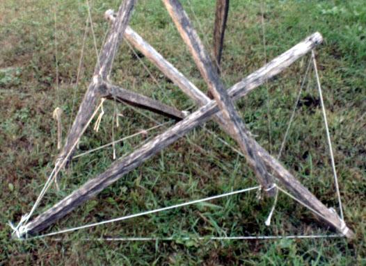 base detail of garden-stake-and-nylon-twine tensegrity bean teepee on grass