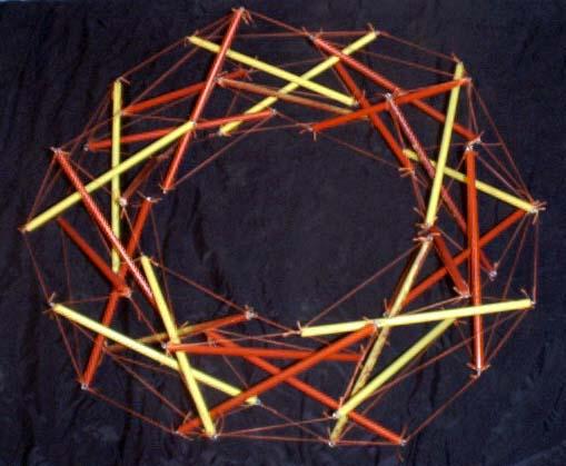 oblique view of dowel-and-fishing-line tensegrity torus on black background